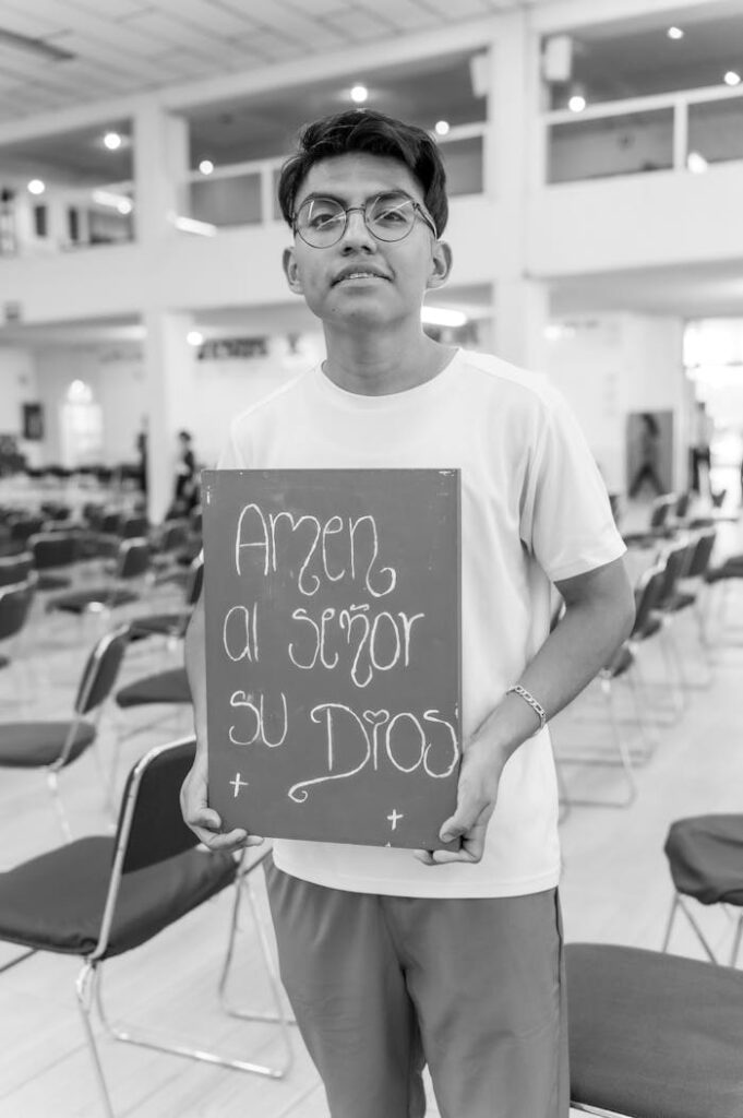 Young man holding a religious sign inside a church in Mexico City.